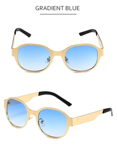 Détail de lunettes de soleil ovales en métal doré avec verres dégradés bleus et embouts noirs