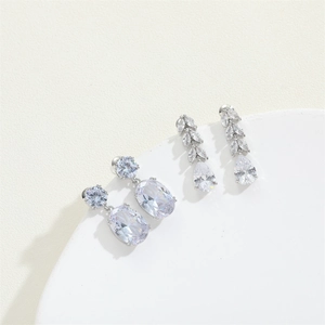 Elegant silver leaf drop earrings with marquise and pear cut crystals on white pedestal