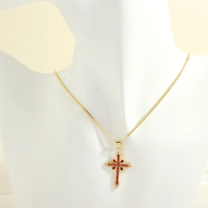 Detail of 18K gold cross pendant with red marquise stones on flat snake chain