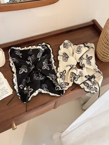 Detailed view of floral hair scrunchies with lace edges, ribbon bows and pearl charms