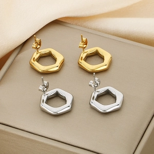 Detailed view of hollow hexagonal stud earrings in gold and silver stainless steel
