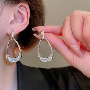 Elegant silver-tone teardrop earrings with sparkling pave zirconia shown on model