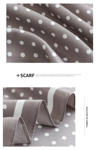 Macro shot of grey silk scarf featuring white polka dot pattern and soft fabric texture