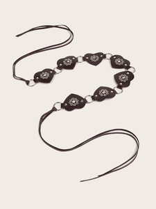 Detail of dark brown heart-shaped leather belt with star rivets and metal rings