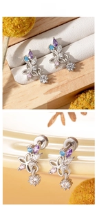 Detailed macro view of butterfly stud earrings with colorful zircon stones and drop pendant