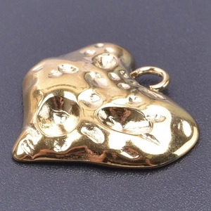 Macro shot of 18k gold plated heart pendant with irregular hammered texture detail