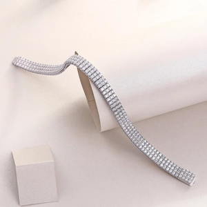 Detailed macro view of high-shine silver triple row tennis bracelet with zircon stones