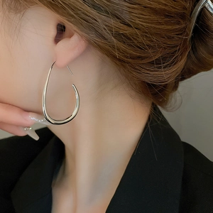 Close-up of polished silver teardrop earrings worn by a model for a stylish look