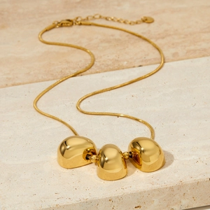 Elegante goldene Edelstahlhalskette mit drei hohlen Anhängern an einer Schlangenkette