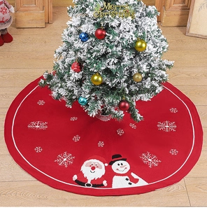 Détail du tapis de sapin de Noël rouge tricoté avec motifs de Père Noël et bonhomme de neige