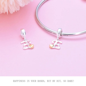 Detailed view of S925 sterling silver letter E charm with gold heart on a silver bracelet