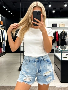 Short en jean bleu clair déchiré pour femme avec un t-shirt blanc à manches courtes
