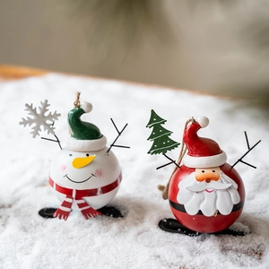 Spherical Christmas metal ornaments featuring snowman and Santa Claus on snow