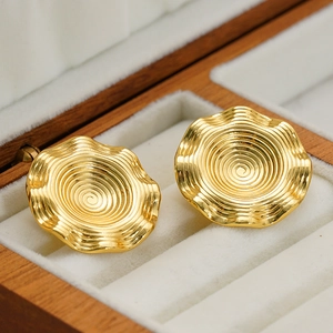 Goldene Titanstahl-Ohrringe mit Spiraltextur und Wellenkante auf Samt-Innenfutter