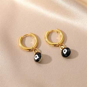 Detailed close-up of golden stainless steel hoop earrings with black evil eye pendants