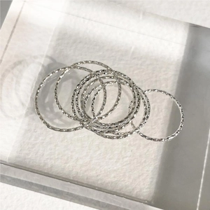 Detailed view of layered 925 sterling silver rings with diamond-cut faceted texture