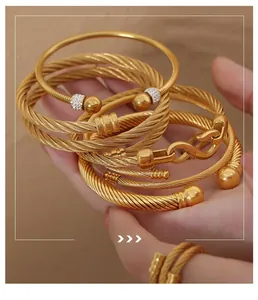 Close-up of gold cable texture bracelets and rings with sparkling zircon inlay details