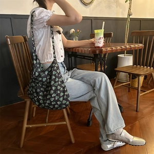 Detail of large dark green floral tote bag with heart pattern and wide canvas strap