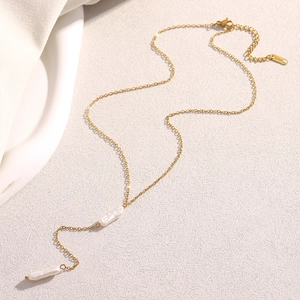 Detail of 18K gold plated Y-necklace with white baroque pearl tassels on silk background