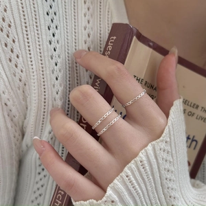 Close-up of a hand wearing three stacked S925 sterling silver hollow heart rings