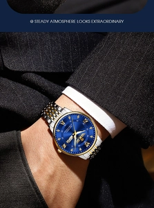 Detail of blue sunray dial watch with luminous hands and date display on a male wrist