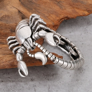Macro detail of vintage silver scorpion king bracelet with aged finish on wood base