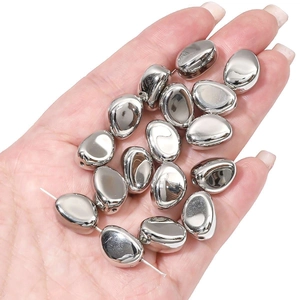 Close-up of metallic silver oval CCB beads for DIY jewelry making on a thin string
