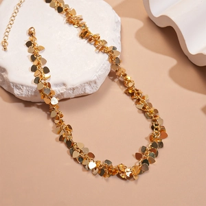 Minimalist gold sequin heart choker necklace with metallic sheen on stone base