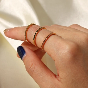 Stackable 18K gold stainless steel rings with colorful zircon crystals on silk cloth