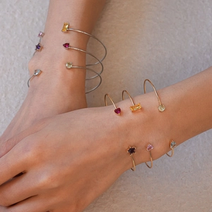 Détail de bracelets ouverts empilables avec zircons portés par un mannequin