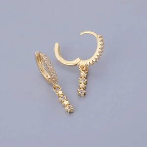 Detail of gold huggie hoop earrings with cascading triple star charms and clear zircon stones