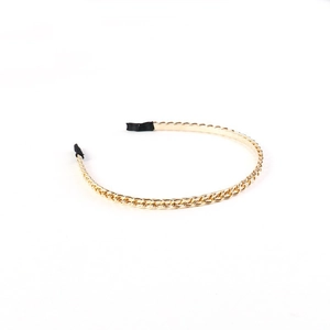Close-up of golden chain headband showing the metal link design and black protective tips