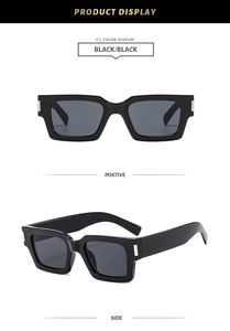 Detail view of square thick black sunglasses with silver rectangular metal accents
