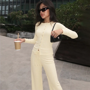 Detail of light yellow knit sports set with cardigan and wide-leg trousers on a model