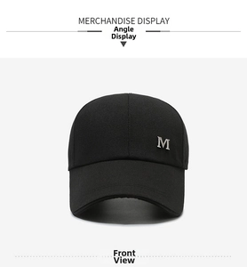Detailed close-up of a black baseball cap featuring a silver metallic letter M logo