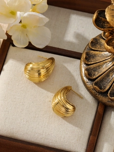 Dettaglio degli orecchini in acciaio inossidabile placcato oro 18k con design a pieghe