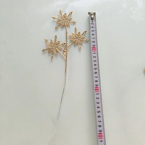 Détail d'un pic floral flocon de neige doré de 23cm avec finition métallique décorative