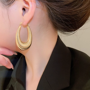 Close-up of elegant gold croissant hoop earrings with polished ribbed texture for women