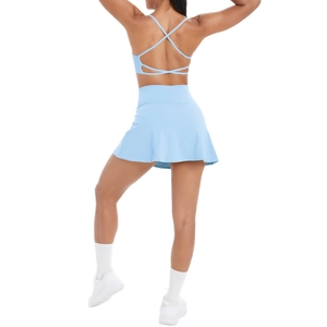 Lichtblauwe tennisrok met hoge taille en sportbeha met kruisbandjes, achteraanzicht