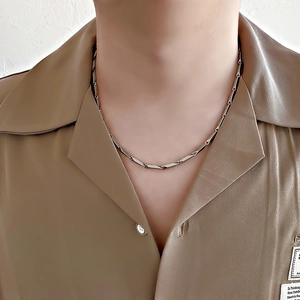 Close-up detail of silver bamboo style titanium steel chain link necklace on model