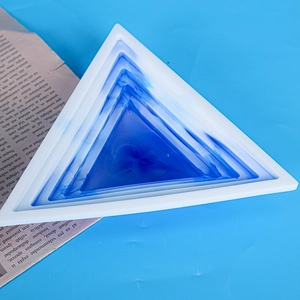 Macro view of a triangular resin tray with blue marble texture and white silicone frame