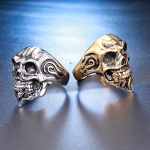 Detailed view of skull rings in silver and gold colors with punk flame engravings