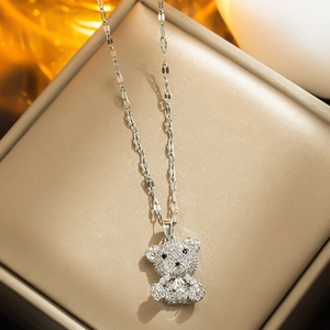 Titanium steel teddy bear pendant necklace with sparkling zircons on a jewelry box
