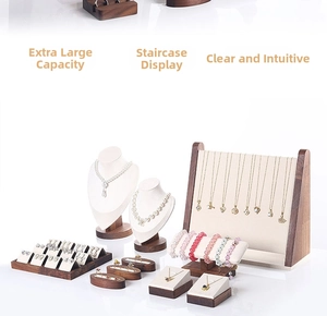 Detailed macro view of walnut wood jewelry display set with cream velvet inserts