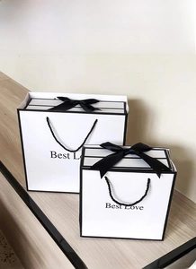 Close-up of white Best Love gift boxes with black ribbon bows in two different sizes