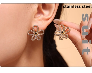 Detail of 18k gold plated hollow flower earrings with sparkling zircons on model