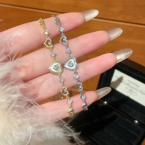 Close-up of gold and silver heart bracelets with cubic zirconia and adjustable chain