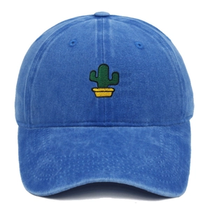 Close-up of green cactus embroidery on a washed blue cotton baseball cap with detail