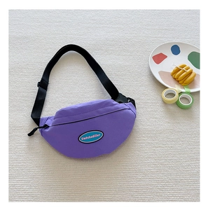 Detail view of purple canvas chest bag with adjustable strap and fashion logo patch