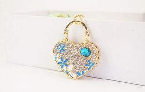 Detailed macro view of heart-shaped handbag keychain with blue gems and floral motifs